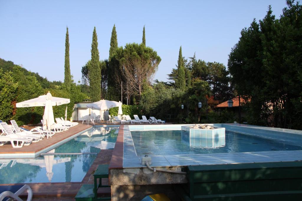 una gran piscina con sillas y una mesa en Villa Felcaro - Relais, Lodge & Restaurant, en Cormòns