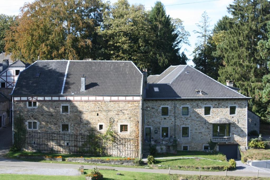 an old stone building with two roofs on top at La lune en bulles in Presseux