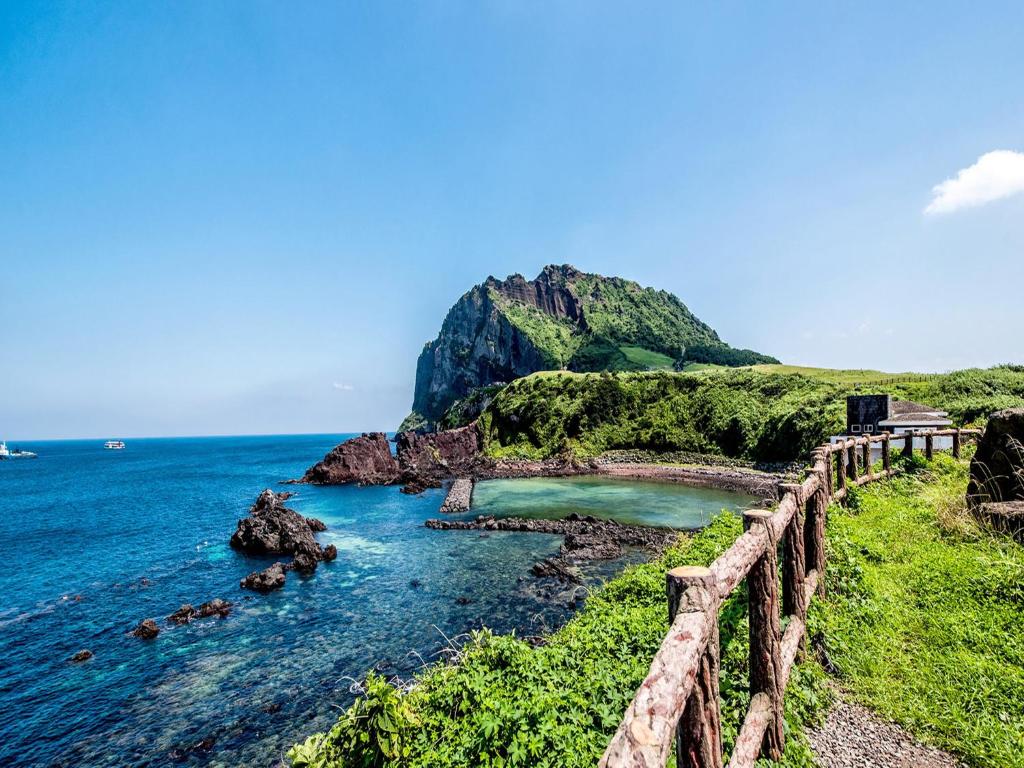 a view of the ocean with a wooden fence at Sea Dragon Pension in Seogwipo