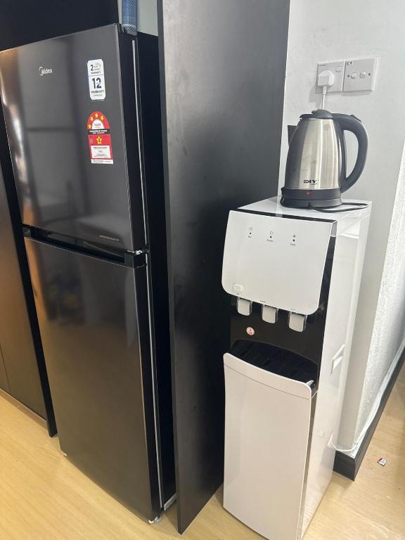 a refrigerator with a tea kettle on top of it at Botaniqa Residence in Puchong