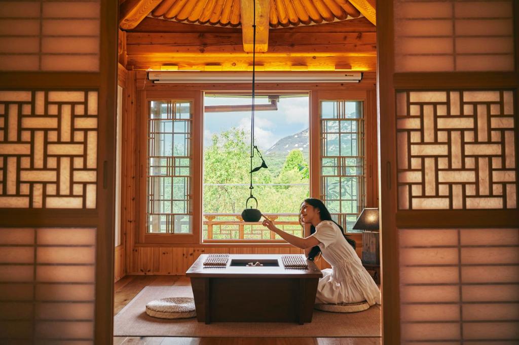 a woman sitting in front of a window in a room at 응정헌 in Seoul