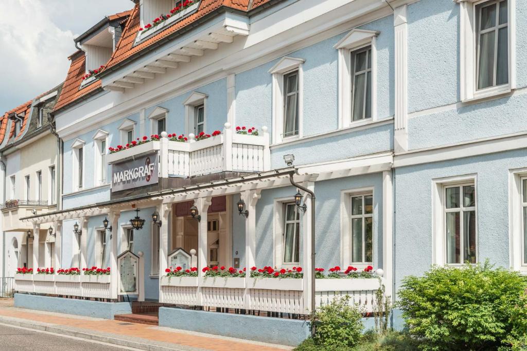 ein Gebäude mit Blumen auf Balkonen auf einer Straße in der Unterkunft Hotel Markgraf in Lehnin