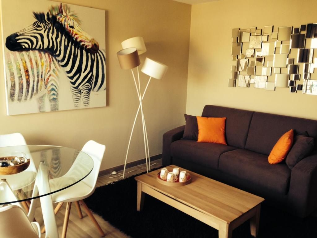 een woonkamer met een bank en een zebraschilderij bij Eden Palace Apartment in Cannes