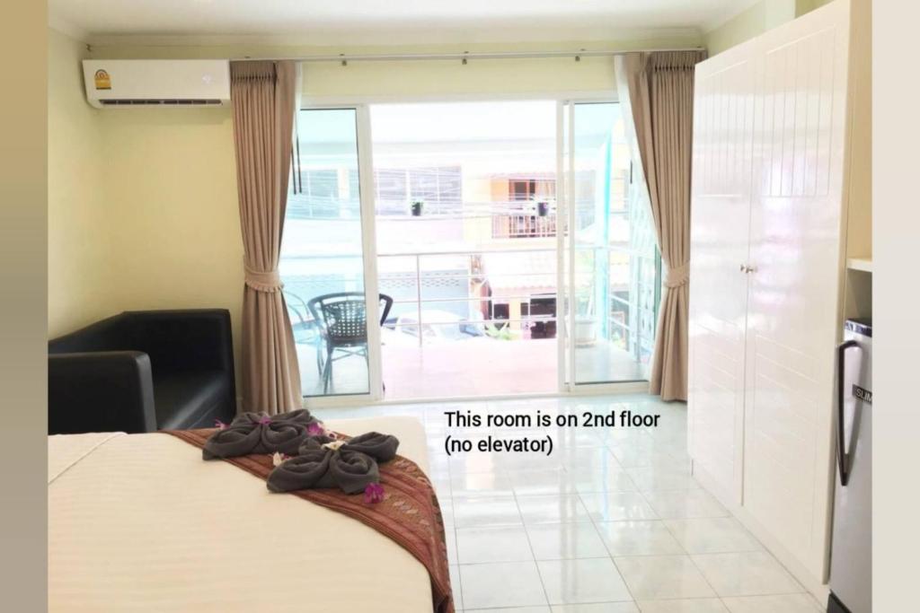 a bedroom with a bed and a balcony at Thai Orchid Guest House in Jomtien Beach
