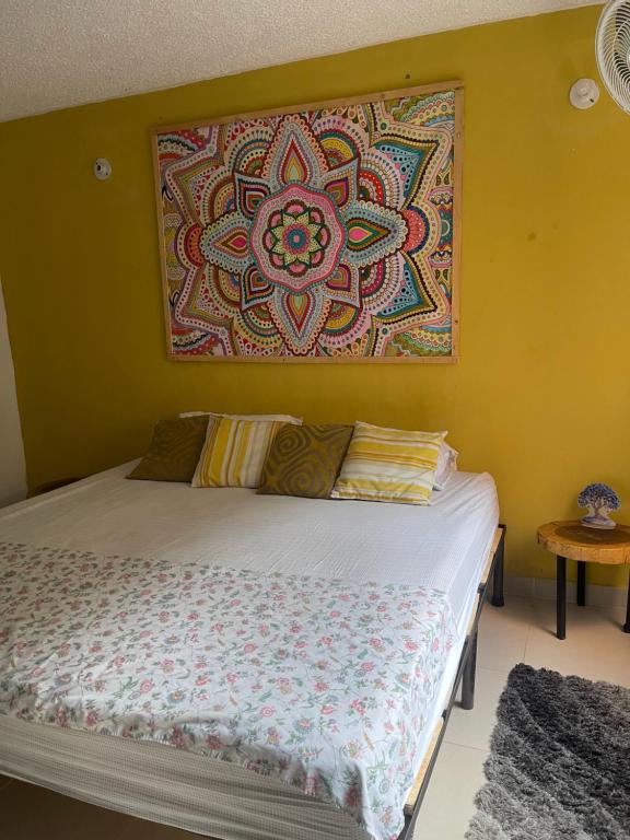 a bed in a room with a painting on the wall at Apartamento en clima caliente in Apulo