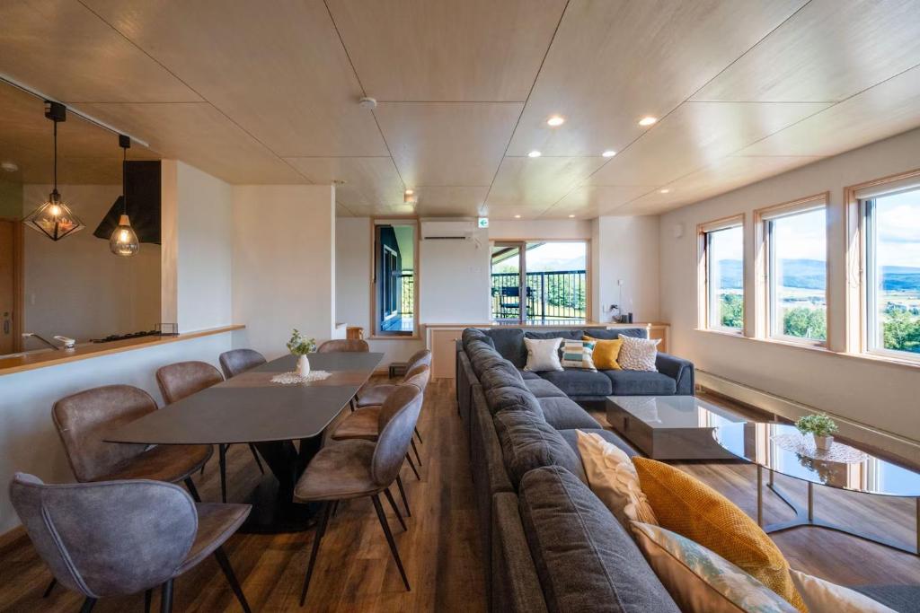 a living room with a couch and a table and chairs at The Kokage in Nakafurano