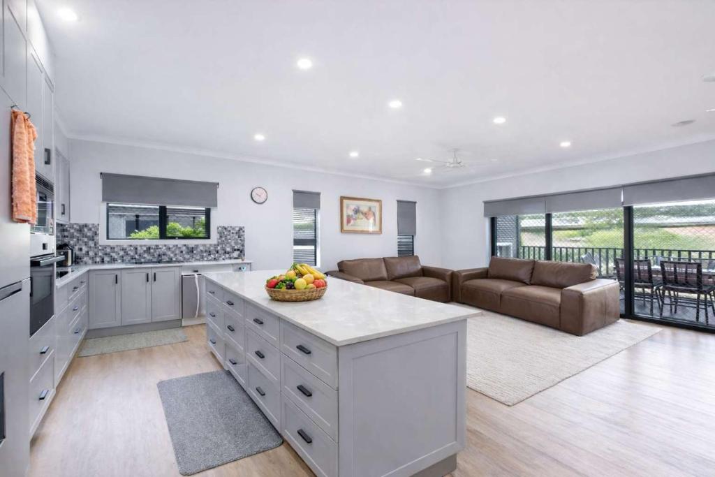 a kitchen and living room with a couch and a table at 4BR Family Home w Golf Course Views, BBQ & Secure Parking in Rosslea