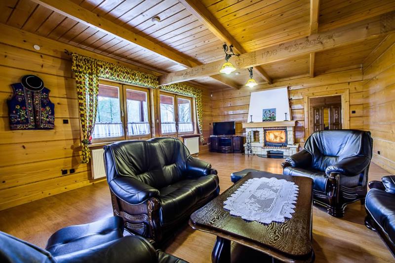 a living room with leather furniture in a cabin at Dom Chata Kowala in Szczawnica