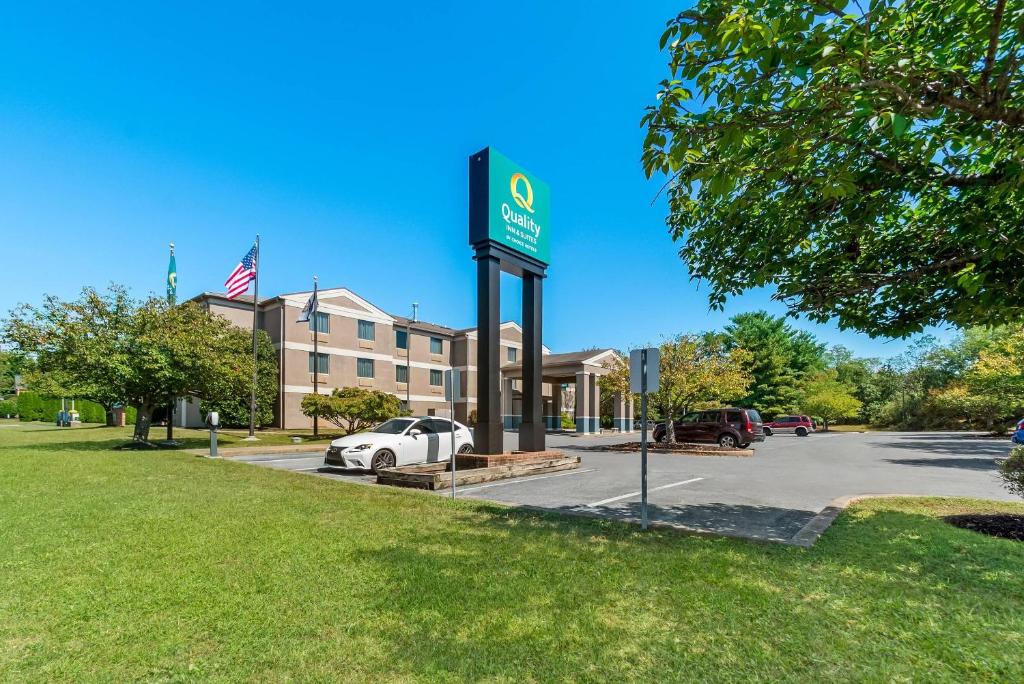 a sign for a hotel with a car parked in a parking lot at Quality Inn & Suites Shepherdstown in Shepherdstown
