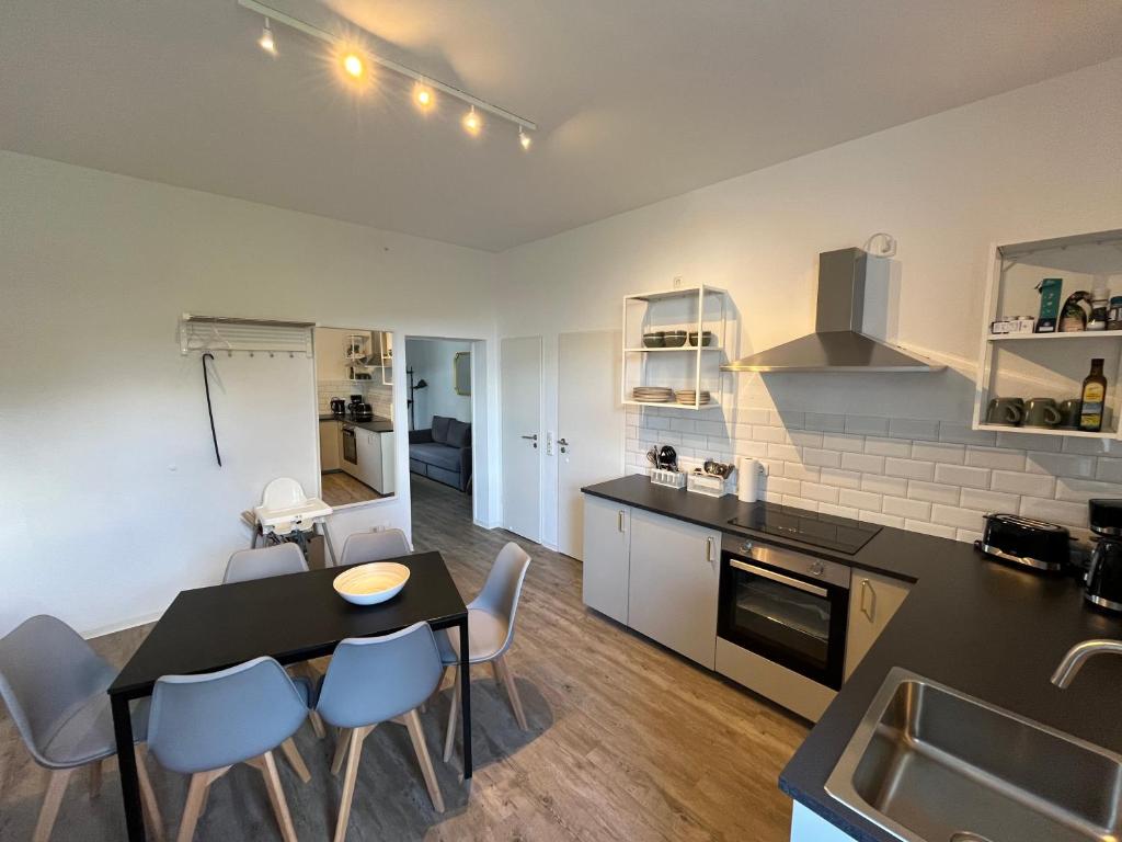 eine Küche und ein Esszimmer mit Tisch und Stühlen in der Unterkunft Small Sally in Gladbeck