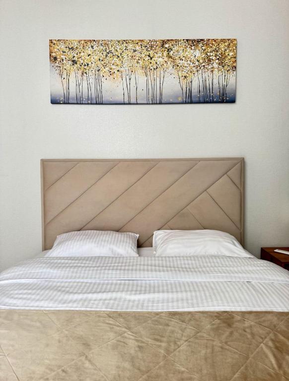 a bedroom with a bed with a painting on the wall at Yu-home in Mukacheve