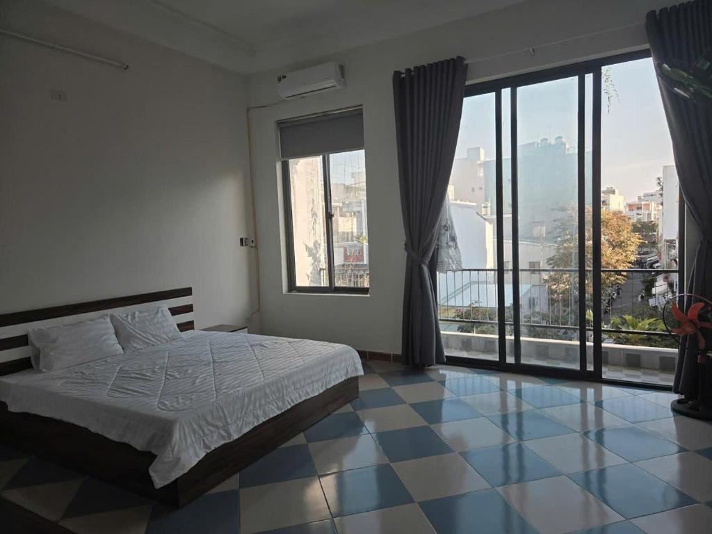 a bedroom with a bed and a large window at THHomestay in Danang