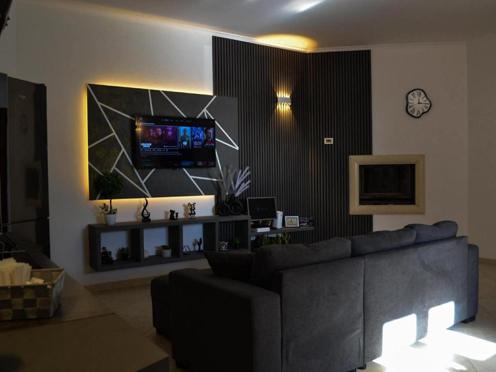 a living room with a couch and a tv on a wall at Villa Alaya in Manduria