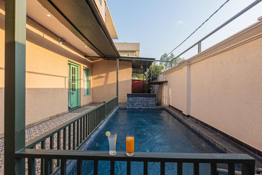 a swimming pool on the balcony of a building with a drink at Trideus The Wild Fraser Corbett in Rāmnagar