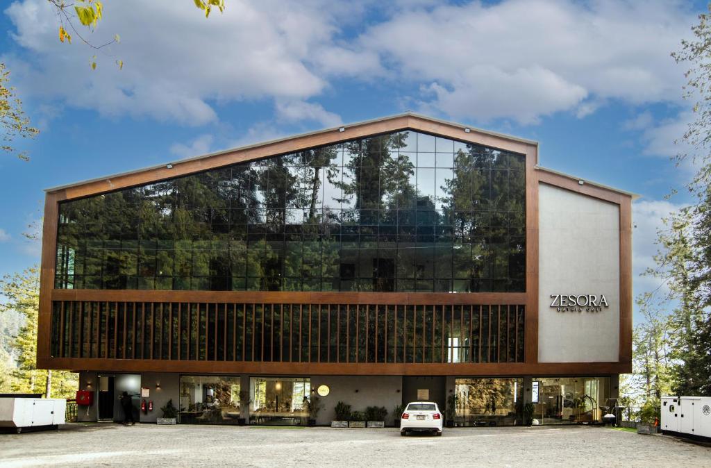 a large glass building with a car parked in front at Zesora Nathia Gali in Nathia Gali