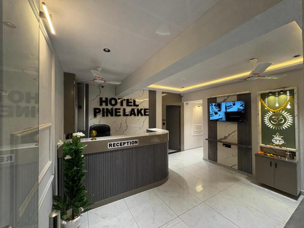 a hotel entrance with a hotel pineapplelake sign in a lobby at Hotel Pine Lake in Ahmedabad