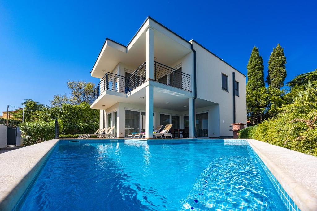 a house with a swimming pool in front of a house at VILA PALISKA in Pula