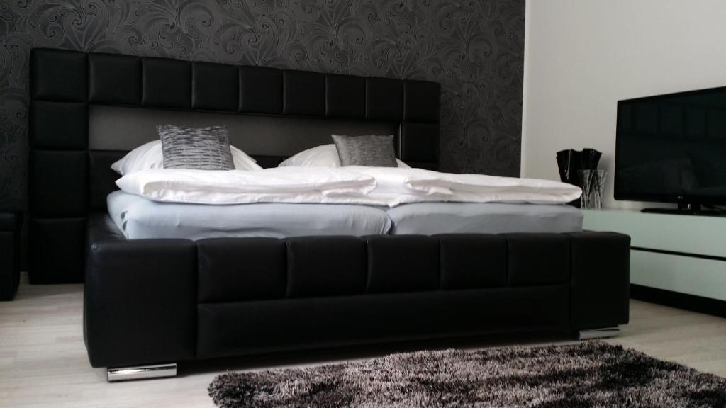 um quarto com uma cama e um sofá de couro preto em Homestay Olivera em Bohumín