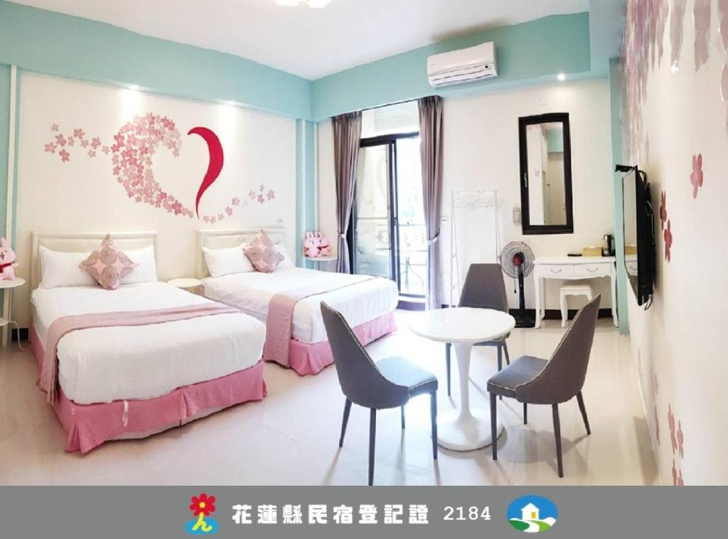 a hotel room with two beds and a table and chairs at Happiness 1799 幸福有約1799民宿電梯花蓮火車站東出口 - 證號 2184-English welcome in Hualien City