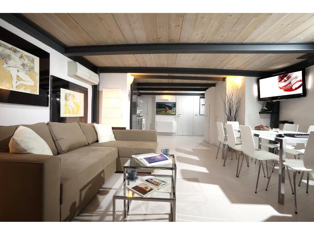 a living room with a couch and a table and chairs at Rome Luxury Rental - Vicolo Palle in Rome
