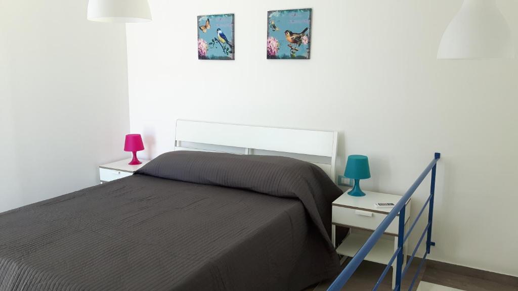 スコペッロにあるBorgo Holiday Homeのベッドルーム1室(ベッド1台、ランプ付きテーブル付)