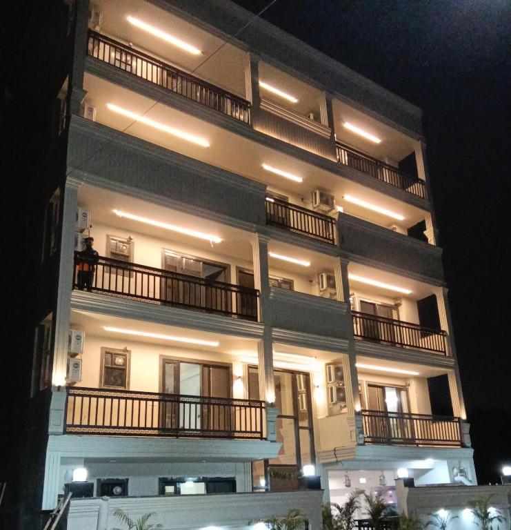 a large white building with balconies at night at Ganga Aura in Gurgaon