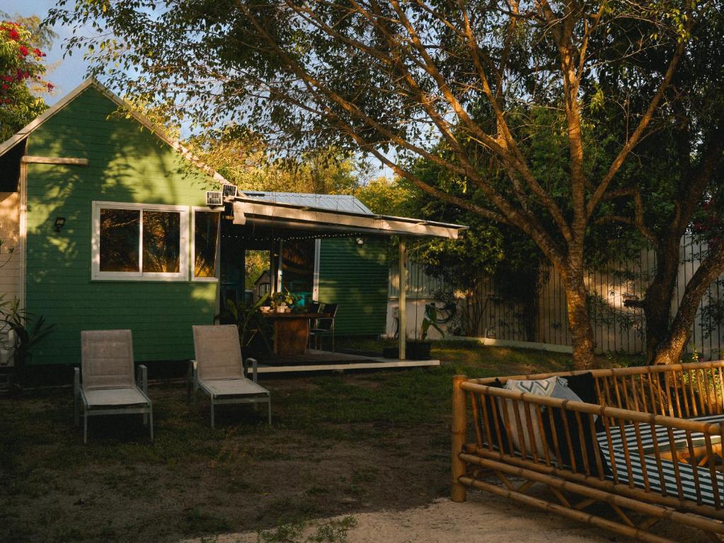 a green house with two chairs and a bench at Three Palms - Beach Front Tiny House by SP Villa in Nathon Bay