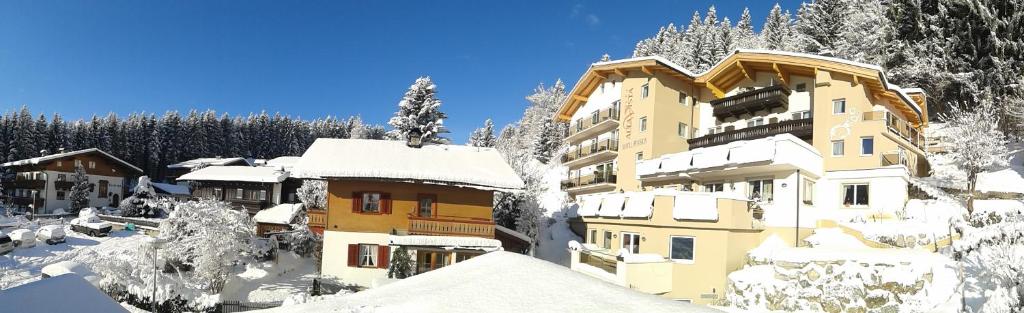 un bâtiment recouvert de neige dans les montagnes dans l'établissement Hotel Alta Vista, à Neukirchen am Großvenediger