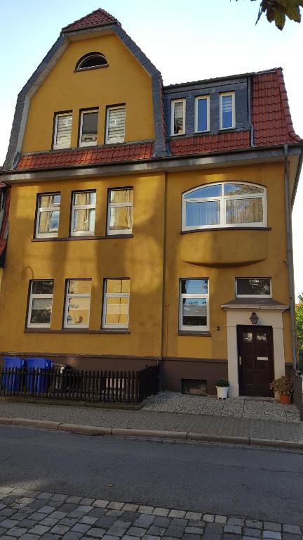 a yellow house on the side of a street at Erboys Ferienwohnung in Goslar