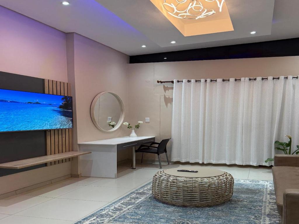 a living room with a tv and a table and a mirror at Deluxe Nest - Windhoek in Windhoek
