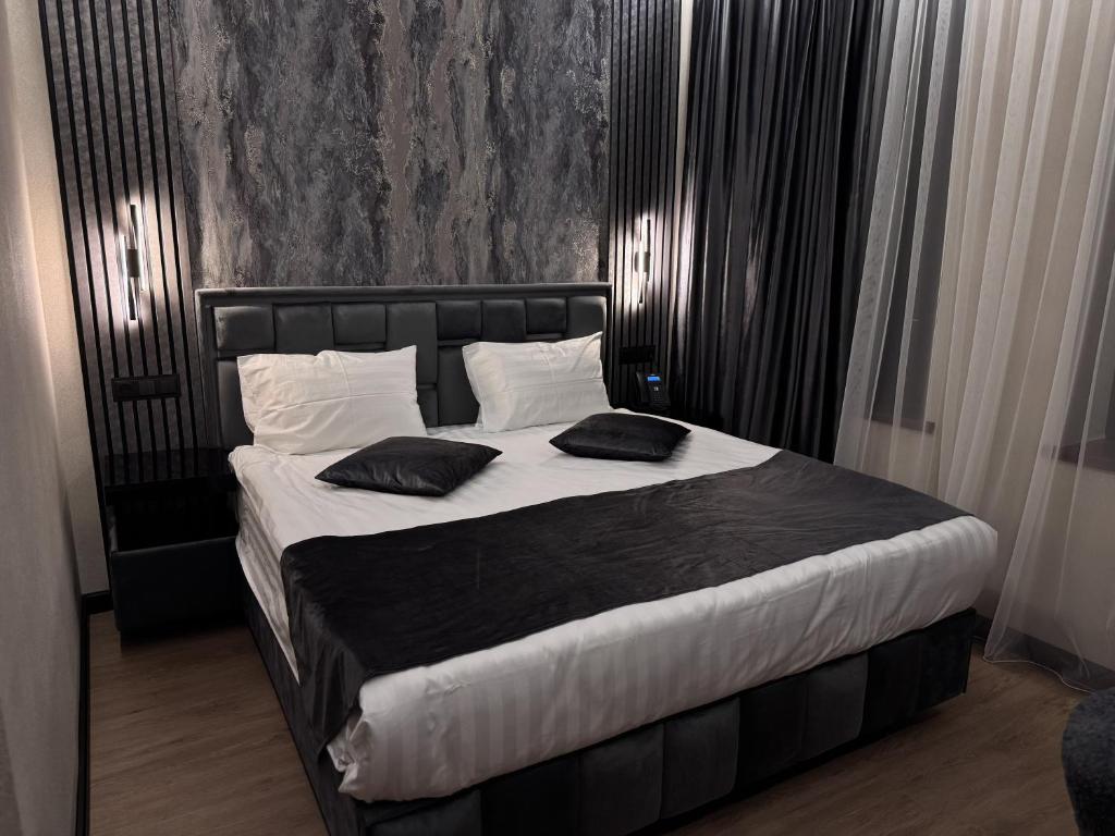 a bedroom with a large bed with two pillows on it at Gyumri Moderna in Gyumri