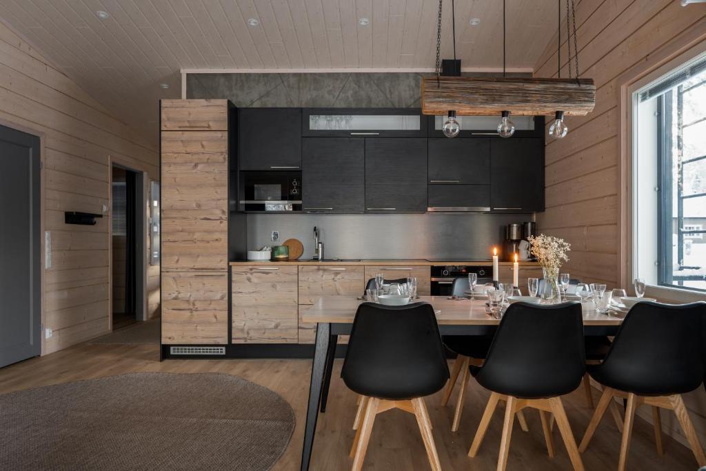 a kitchen with a table and black chairs at Louhi A in Äkäslompolo