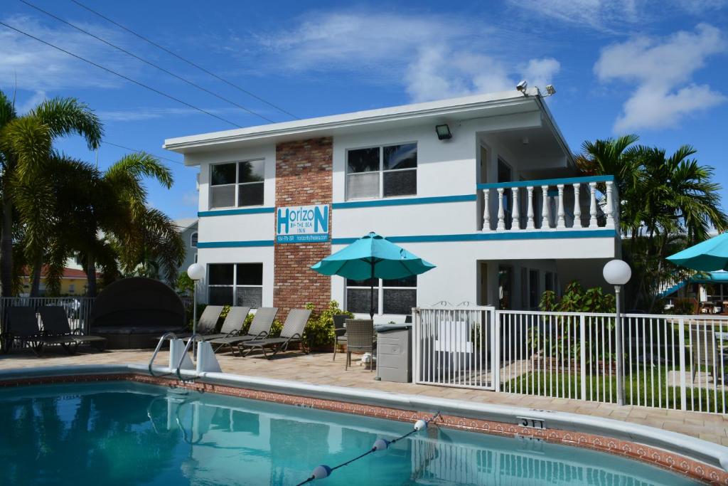 a house with a swimming pool in front of a building at Horizon by the Sea Inn in Fort Lauderdale