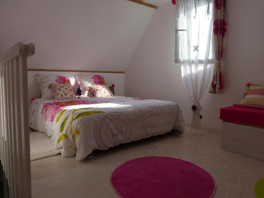 a bedroom with a bed and a purple rug at Le Diamant in Le Minihic-sur-Rance