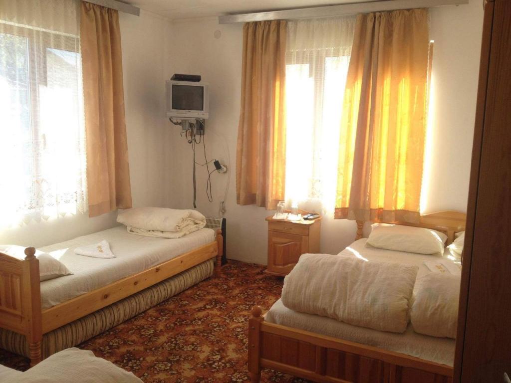アプリルツィにあるGuest rooms Dyado Sabchoのベッドルーム1室(ベッド2台、テレビ、窓付)