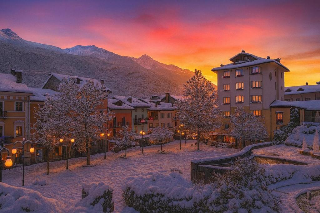 a city in the snow at sunset with mountains at MontBliss in Saint Vincent