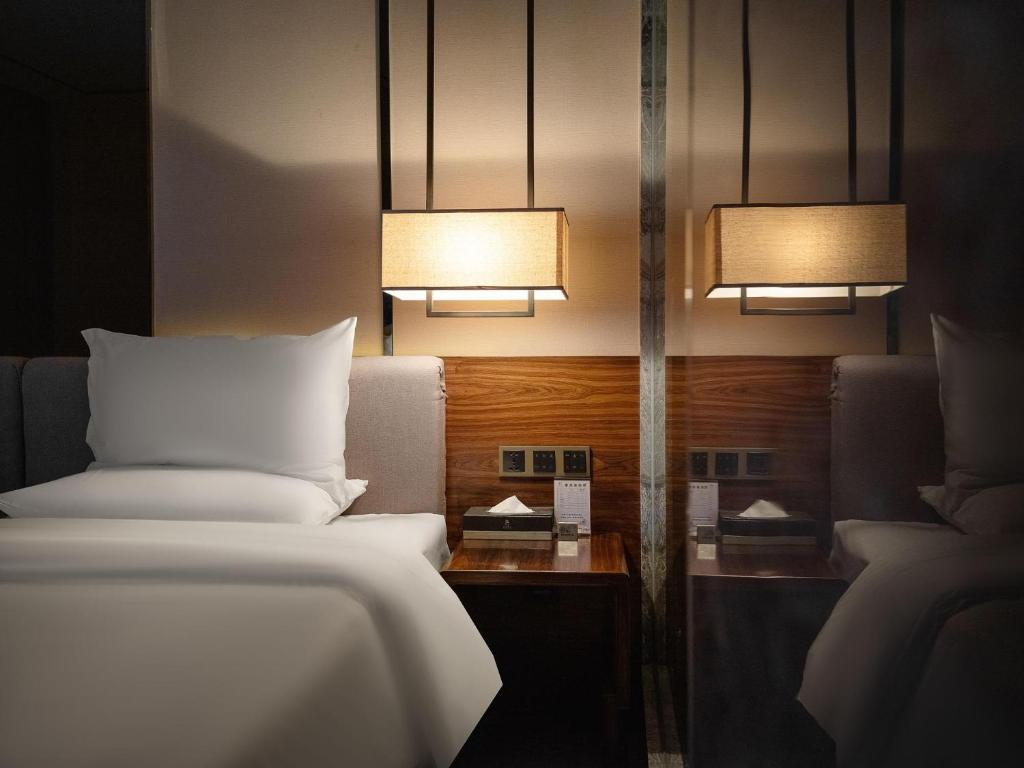 a hotel room with a bed and two lights at 半山酒店 in Kaili
