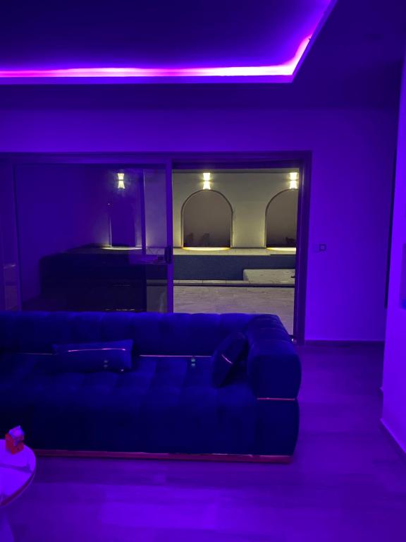 ein Wohnzimmer mit violettem Licht und einem Sofa in der Unterkunft DarDif in Wadrān
