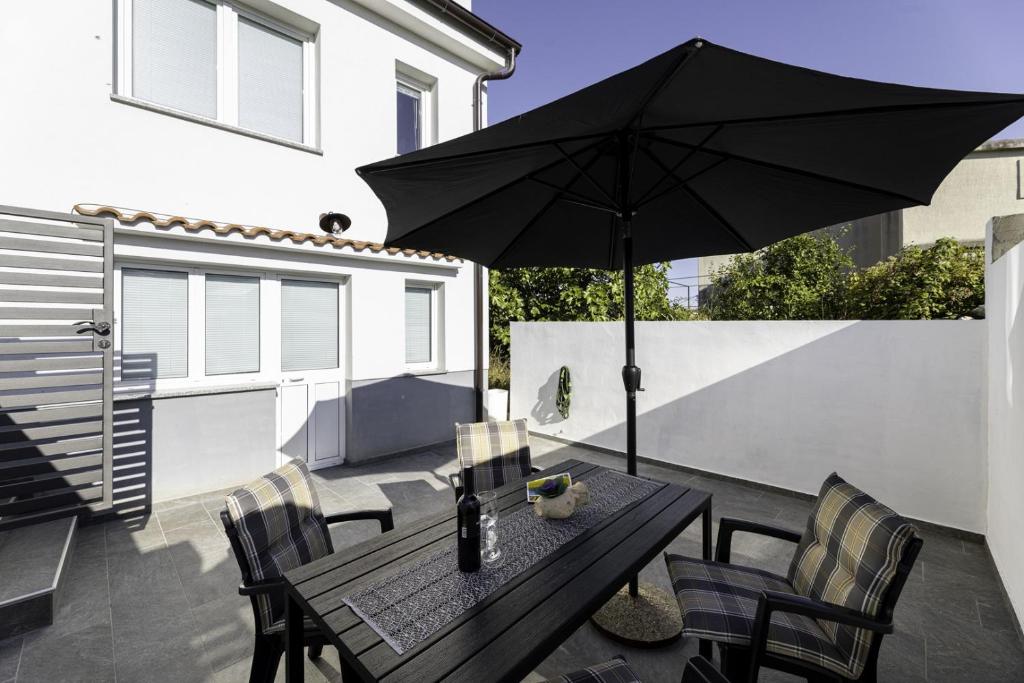 a table with an umbrella on a patio at Apartment Jelusic in Baška