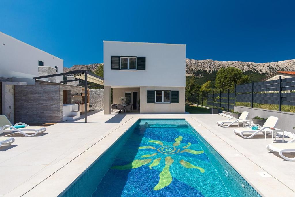 a villa with a swimming pool and a house at Villa Aurora in Baška