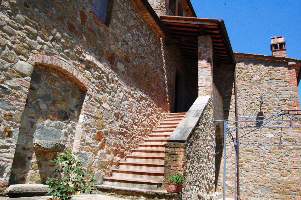 un edificio de ladrillo con escaleras en el costado en Borgo Nuovo San Martino, en Ambra