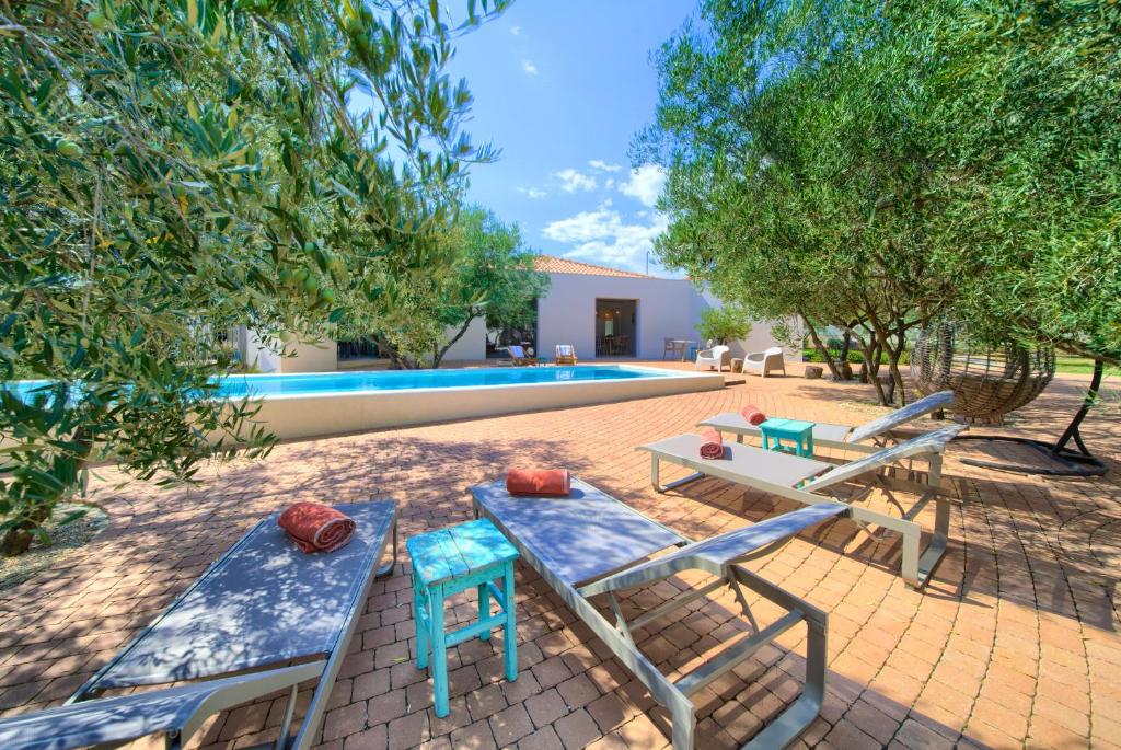 a patio with two lounge chairs and a swimming pool at Margari Villas in Linardići