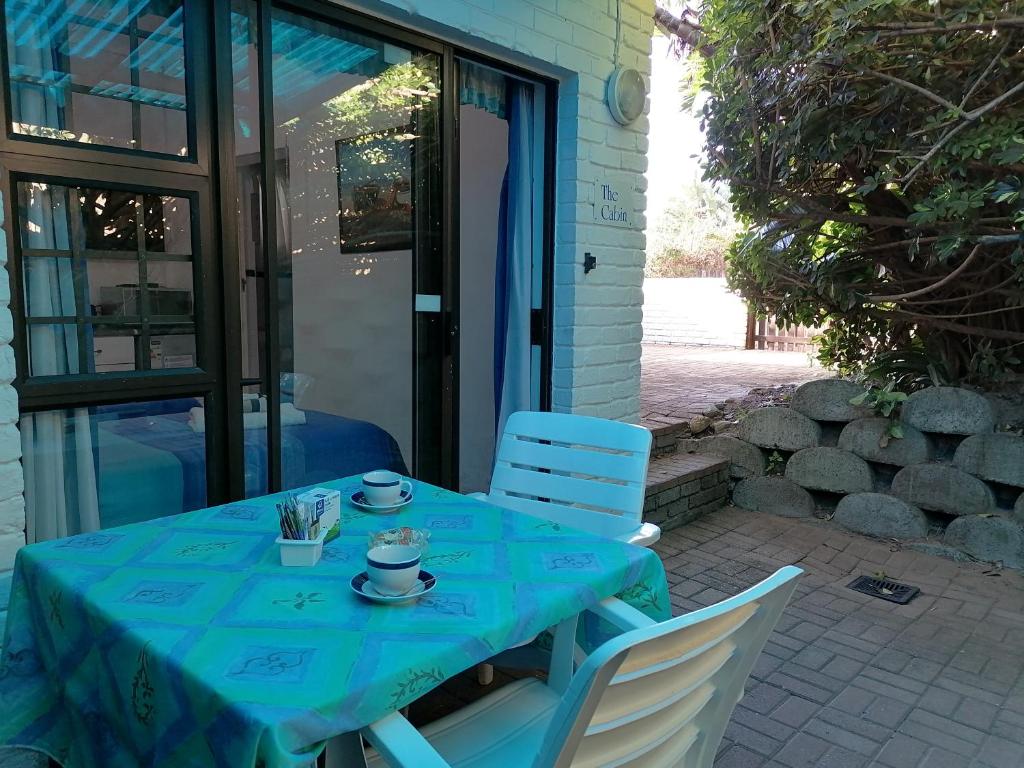 a table with a blue table cloth and two chairs at Boathouse Bed and Biscuit - Cabin in Margate