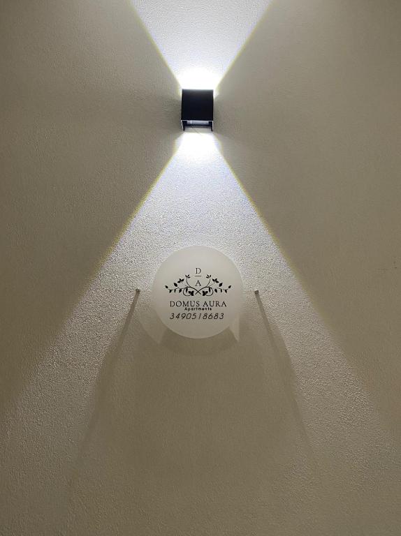 a light on a ceiling with a sign on it at Domus Aura Apartments in SantʼAntìoco