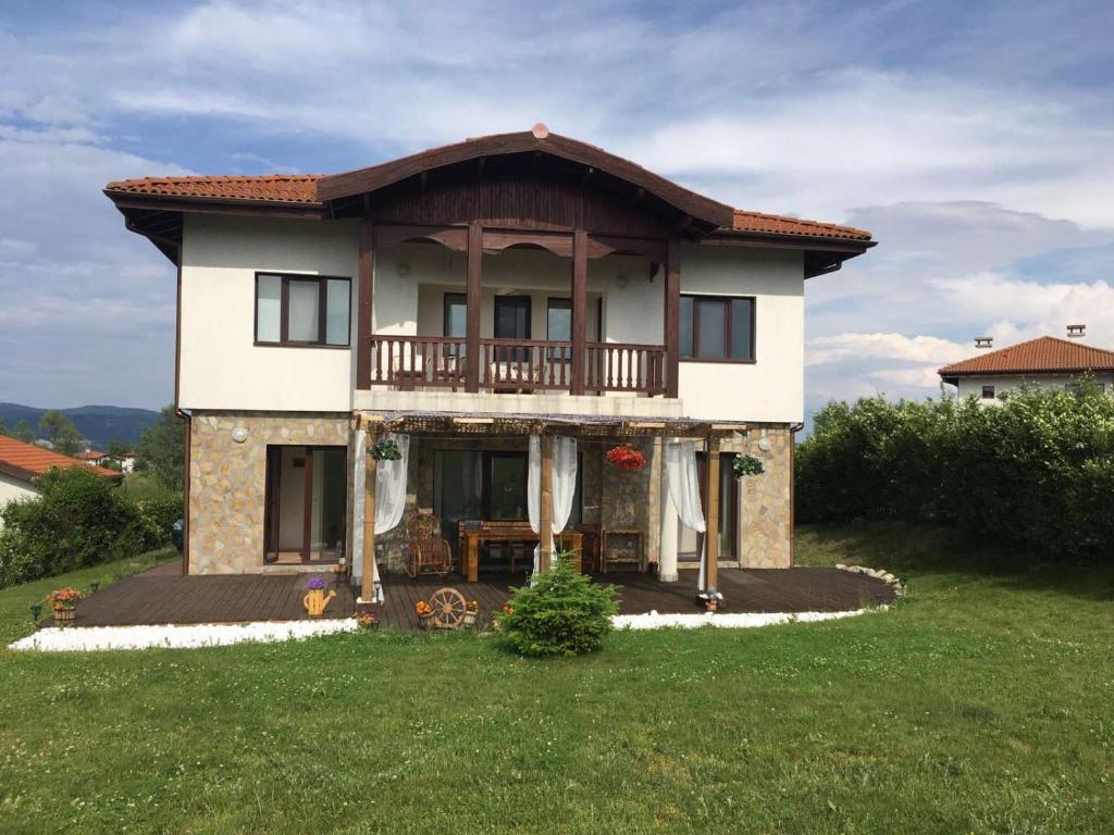 ein Haus mit Balkon über einem Hof in der Unterkunft Villa Dreams in Golf Club Ibar in Dolna Banya