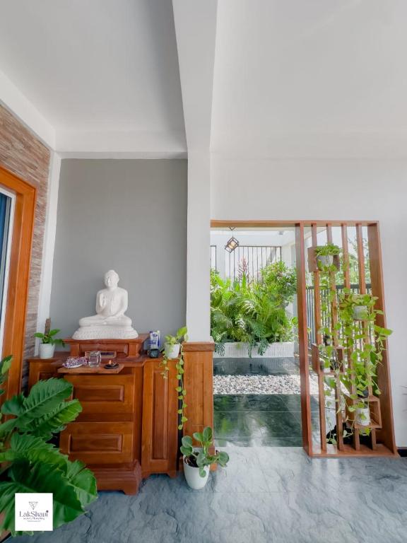 a room with a wooden dresser and some plants at Lakshani Villa in Polonnaruwa