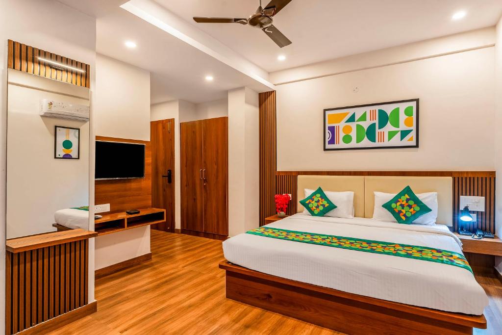 a bedroom with a large bed and a television at Treebo Adithi Comforts Inn And Suites in Mysore