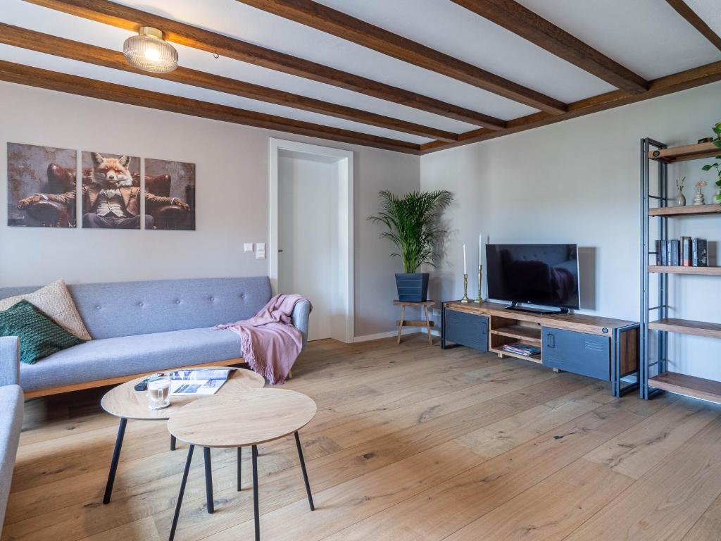 a living room with a couch and a tv at Fuchsbau nähe Sorpesee, ebenerdig mit Kamin und Garten in Sundern