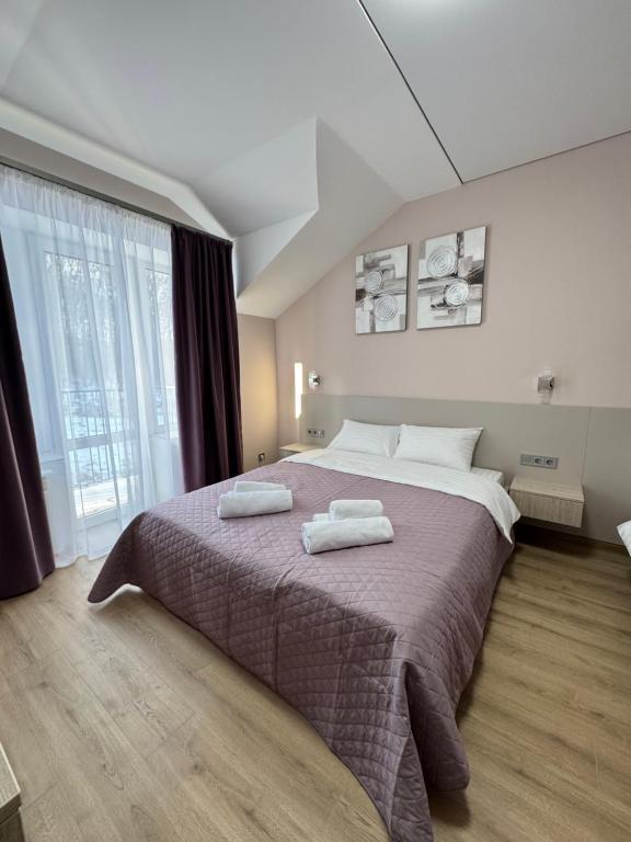 a bedroom with a large bed with two towels on it at Polyana Park House aparts in Polyana