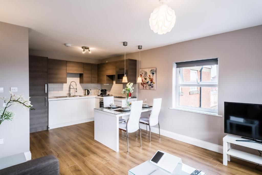 a kitchen and living room with a table and chairs at Fishergate Apartments in Preston